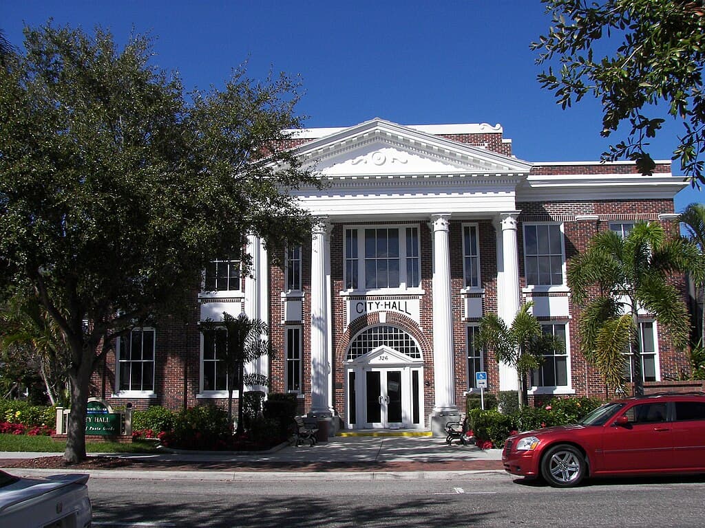 Charlotte County Courthouse in Punta Gorda, Florida, featuring historic architecture with columns and an American flag in front Charlotte County Courthouse in Punta Gorda, Florida, featuring historic architecture with columns and an American flag in front