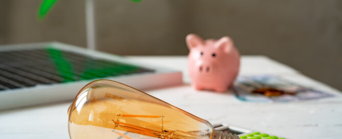 Sustainable home energy savings tools including LED light bulb, calculator, and solar panel model representing eco-friendly home upgrades in Sarasota, Mirasol Solar